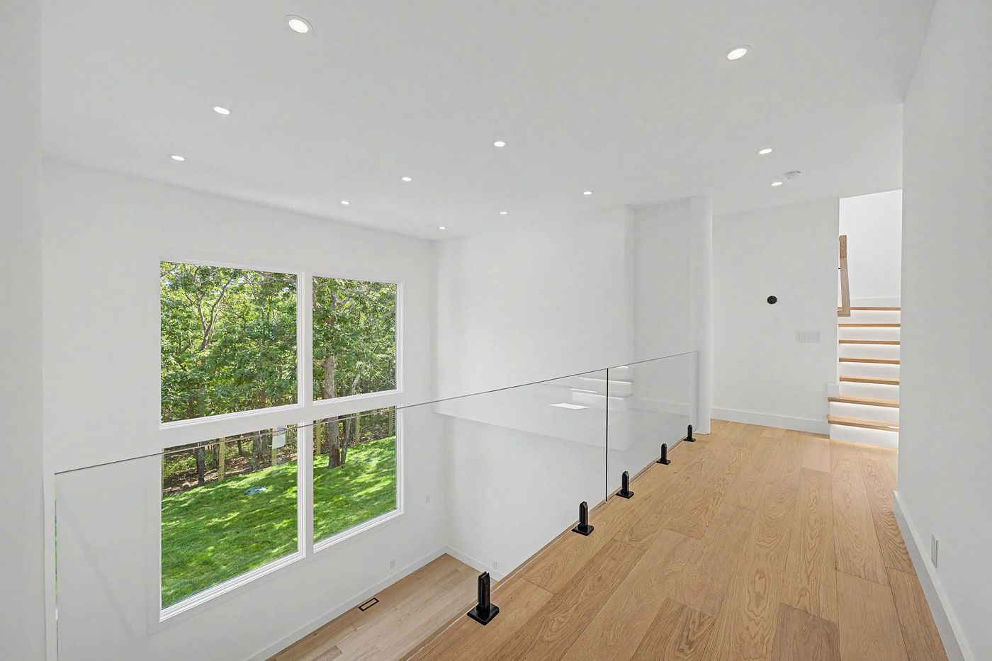 Upper landing with glass rail overlooking the great room