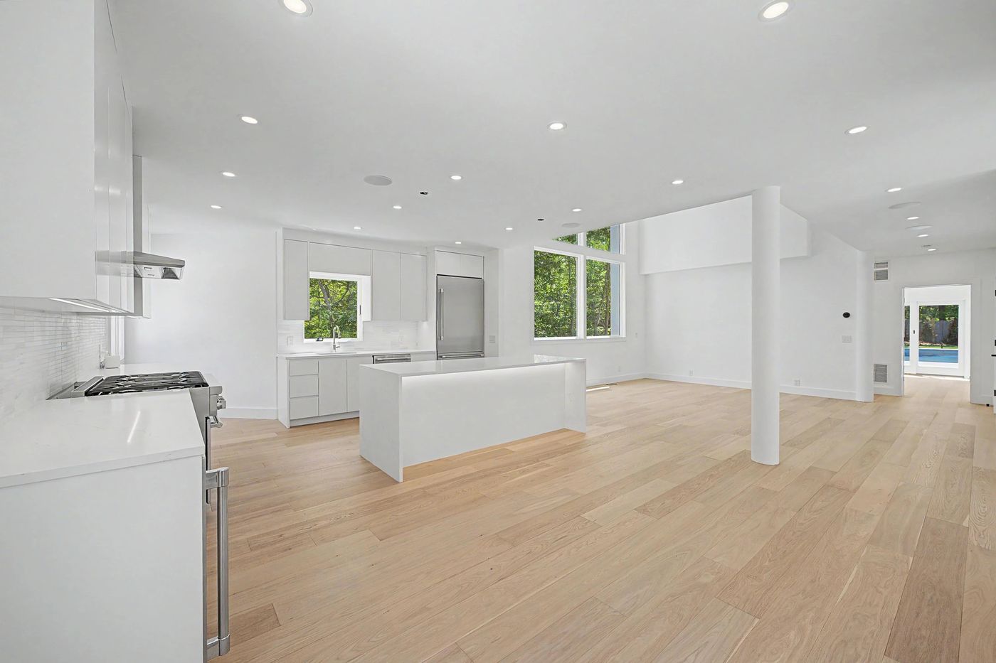 Open-plan kitchen and living level with view to the pool