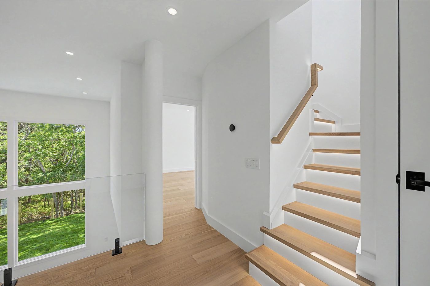 Interior staircase in white oak with glass rail